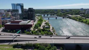 Bir sürü penceresi ve camında arabaların yansıması olan büyük bir bina. Bina içinde birçok arabanın park edildiği bir otoparkla çevrili.