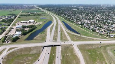 Bir sürü penceresi ve camında arabaların yansıması olan büyük bir bina. Bina içinde birçok arabanın park edildiği bir otoparkla çevrili.