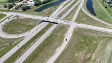 Bir sürü penceresi ve camında arabaların yansıması olan büyük bir bina. Bina içinde birçok arabanın park edildiği bir otoparkla çevrili.