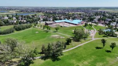 Bir sürü penceresi ve camında arabaların yansıması olan büyük bir bina. Bina içinde birçok arabanın park edildiği bir otoparkla çevrili.