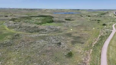 Bir sürü penceresi ve camında arabaların yansıması olan büyük bir bina. Bina içinde birçok arabanın park edildiği bir otoparkla çevrili.