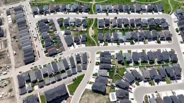 Bir sürü penceresi ve camında arabaların yansıması olan büyük bir bina. Bina içinde birçok arabanın park edildiği bir otoparkla çevrili.