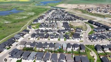 Bir sürü penceresi ve camında arabaların yansıması olan büyük bir bina. Bina içinde birçok arabanın park edildiği bir otoparkla çevrili.