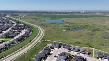 Bir sürü penceresi ve camında arabaların yansıması olan büyük bir bina. Bina içinde birçok arabanın park edildiği bir otoparkla çevrili.