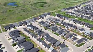 Bir sürü penceresi ve camında arabaların yansıması olan büyük bir bina. Bina içinde birçok arabanın park edildiği bir otoparkla çevrili.