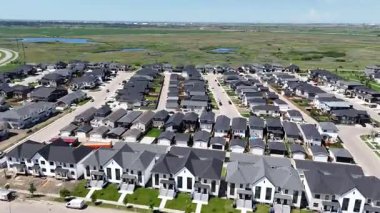 Bir sürü penceresi ve camında arabaların yansıması olan büyük bir bina. Bina içinde birçok arabanın park edildiği bir otoparkla çevrili.