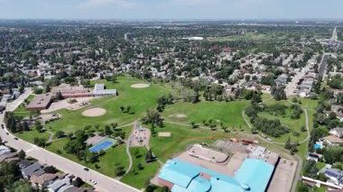 Bir sürü penceresi ve camında arabaların yansıması olan büyük bir bina. Bina içinde birçok arabanın park edildiği bir otoparkla çevrili.