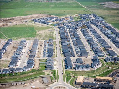 Birçok evi ve birkaç arabası olan bir yerleşim yeri. Evlerin çoğu beyaz ve cadde ağaçlarla kaplı.