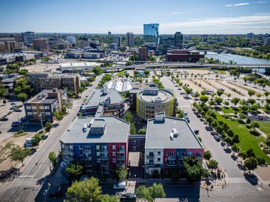 Şehir manzarası yukarıdan, bir sürü bina ve büyük bir otopark. Binalar çoğunlukla kırmızı ve mavi.
