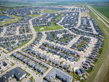 Birçok evi ve birkaç arabası olan bir yerleşim yeri. Evlerin çoğu beyaz ve cadde ağaçlarla kaplı.