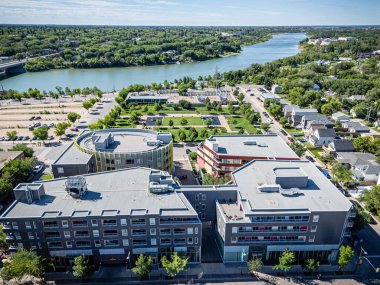 Şehir manzarası ve içinden bir nehir geçiyor. Binalar yüksek ve park yerinde bir sürü araba var.