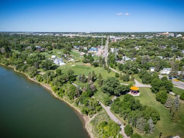 İçinden nehir akan güzel bir şehir manzarası. Şehir ağaçlar ve evlerle dolu.