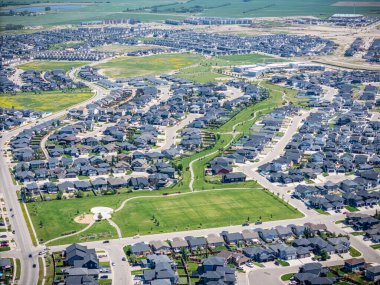 Evleri ve parkı olan bir yerleşim yeri. Evlerin çoğu beyaz ve park yeşil.