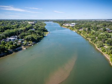 Nehir yeşilimsi bir renk ve kıyılarda birkaç ev. Su sakin ve huzurlu.