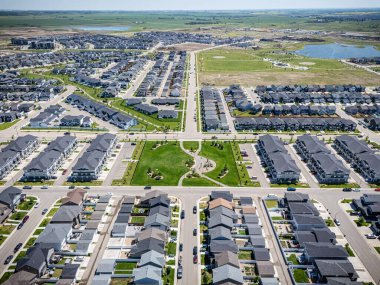Bir sürü evi ve ortasında parkı olan bir banliyö mahallesi. Evlerin çoğu beyaz ve park çitlerle çevrili.