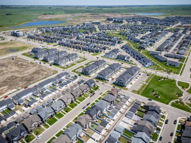 Birçok evi ve birkaç arabası olan bir yerleşim yeri. Evlerin çoğu beyaz ve cadde ağaçlarla kaplı.