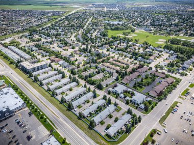 Bir sürü evi ve otoparkı olan bir şehir manzarası. Evlerin çoğu beyaz ve otopark arabalarla dolu.