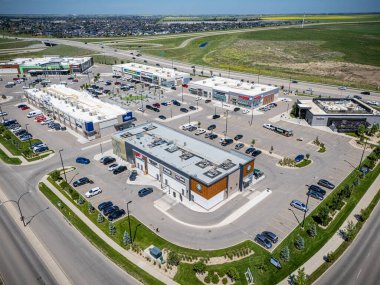 Bir sürü park yeri olan büyük bir alışveriş merkezi. Alışveriş merkezi çimenli bir alanla çevrilidir.