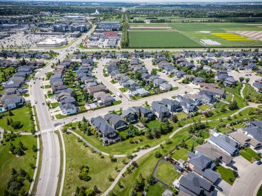 Evleri ve birkaç arabası olan bir yerleşim yeri. Evlerin çoğu beyaz ve cadde ağaçlarla kaplı.