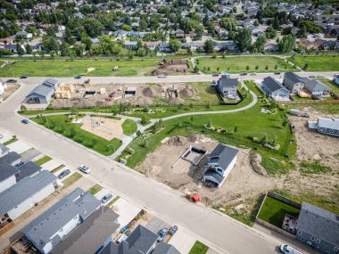 Evleri ve parkı olan bir yerleşim yeri. Evler inşa ediliyor ve bölgede inşaat alanları var.