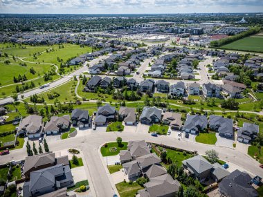 Evleri ve parkı olan bir yerleşim yeri. Evlerin çoğu beyaz ve park yeşil.