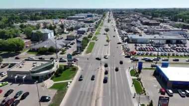 Bir sürü arabası ve otoparkı olan kalabalık bir cadde. Sahne meşgul ve hareketli.
