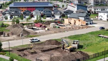 Kamyonu ve kepçesi olan bir inşaat alanı. Kazı kazma toprağı kazıyor.