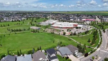 Evleri ve parkı olan bir yerleşim yeri. Park evlerle çevrili ve yeşil çimenli bir alanı var.