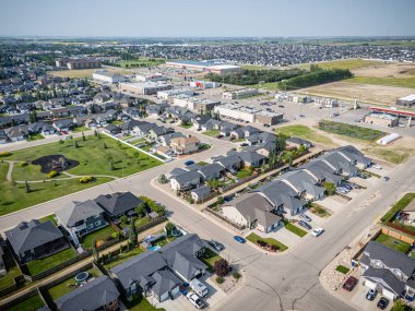 Evleri ve birkaç arabası olan bir yerleşim yeri. Evlerin çoğu beyaz ve cadde ağaçlarla kaplı.