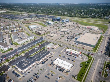 Bir sürü bina ve arabalı şehir manzarası. Binaların çoğu beyaz ve caddeye park edilmiş bir sürü araba var.