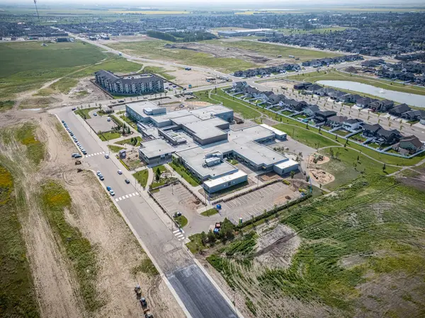 Arkasında bina olan büyük boş bir arazi. Bina bir okul. Görüntüde hiç insan yok.