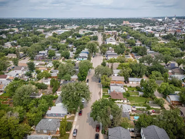 Yukardan görünen evler ve ağaçlarla dolu bir şehir. Evler yayılıp ağaçlar doğal bir güzellik hissi verdiği için manzara sakin ve huzur dolu. Aşağıdaki sokak evlerle dolu.