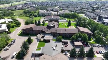 Merkezinde büyük bir bina olan büyük yeşil bir park. Bina ağaçlarla çevrili ve tepesinde bir kubbe var.