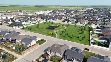 Evleri ve parkı olan bir yerleşim yeri. Evlerin çoğu beyaz ve park yeşil.