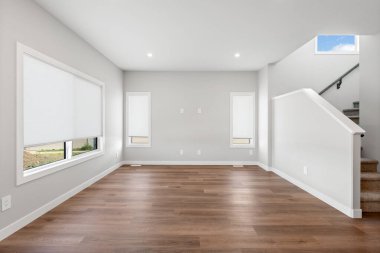 Arkasında merdiven olan büyük, boş bir oda. Oda çok temiz ve minimalist bir havası var.