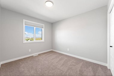 Büyük, penceresi ve kapısı olan boş bir oda. Oda çok temiz ve çok basit bir tasarımı var.