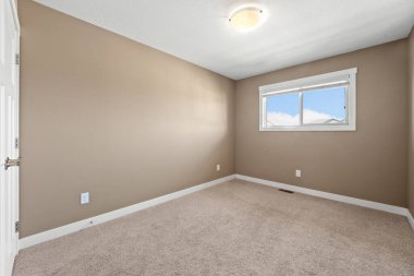 Beyaz duvarı ve penceresi olan bir oda. Oda boş ve açık renkli.