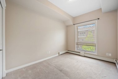 Beyaz duvarı ve penceresi olan bir oda. Pencerenin perdeleri var ve oda boş.