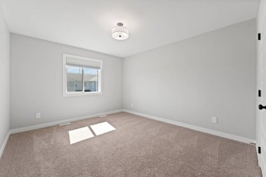 Beyaz duvarı ve penceresi olan bir oda. Oda boş ve açık renkli.