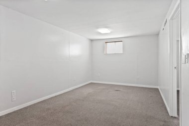 Beyaz duvarı ve penceresi olan çok boş bir oda. Oda boş ve hiç mobilyası yok.