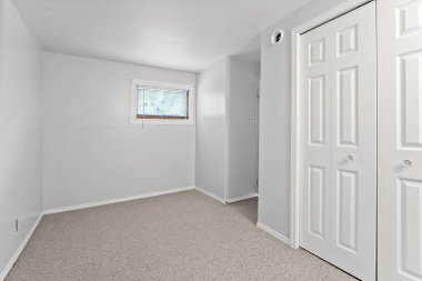 Penceresi ve kapısı olan beyaz bir oda. Oda boş ve minimalist bir görünüşü var.