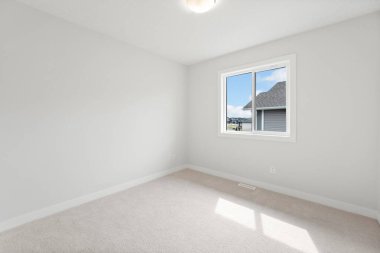 Penceresi ve beyaz duvarı olan beyaz bir oda. Oda boş ve minimalist bir görünüşü var.