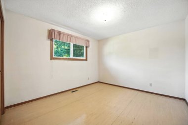 Beyaz duvarı ve penceresi olan bir oda. Oda boş ve çok temiz ve basit bir görünüşü var.