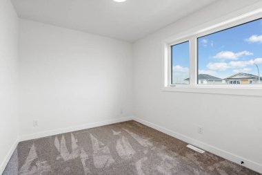 Penceresi ve halısı olan küçük, boş bir oda. Oda çok temiz ve dağınık, sakin ve huzurlu bir atmosfer sağlıyor.