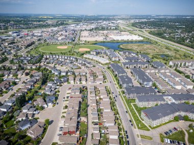 Bir sürü evi ve birkaç arabası olan bir yerleşim yeri manzarası. Evler çoğunlukla beyaz ve arabalar çoğunlukla kırmızı.