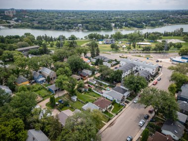 Şehir manzarası ve içinden bir nehir geçiyor. Evler küçük ve cadde ağaçlarla kaplı.