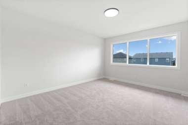 Büyük, penceresi ve aydınlatma armatürü olan boş bir oda. Oda çok temiz ve havadar bir havası var.