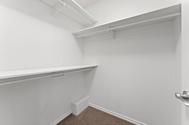 Rafı ve kutusu olan beyaz bir dolap. Dolap boş. Kutu yerde.