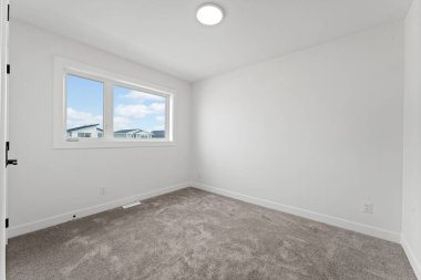 Penceresi ve kapısı olan beyaz bir oda. Oda boş ve minimalist bir görünüşü var.