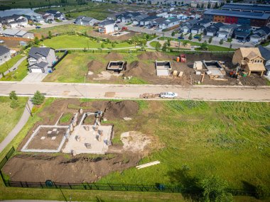 Ortasında inşaat alanı olan bir yerleşim yeri. Evler inşa ediliyor ve inşaat alanı çitlerle çevrili.